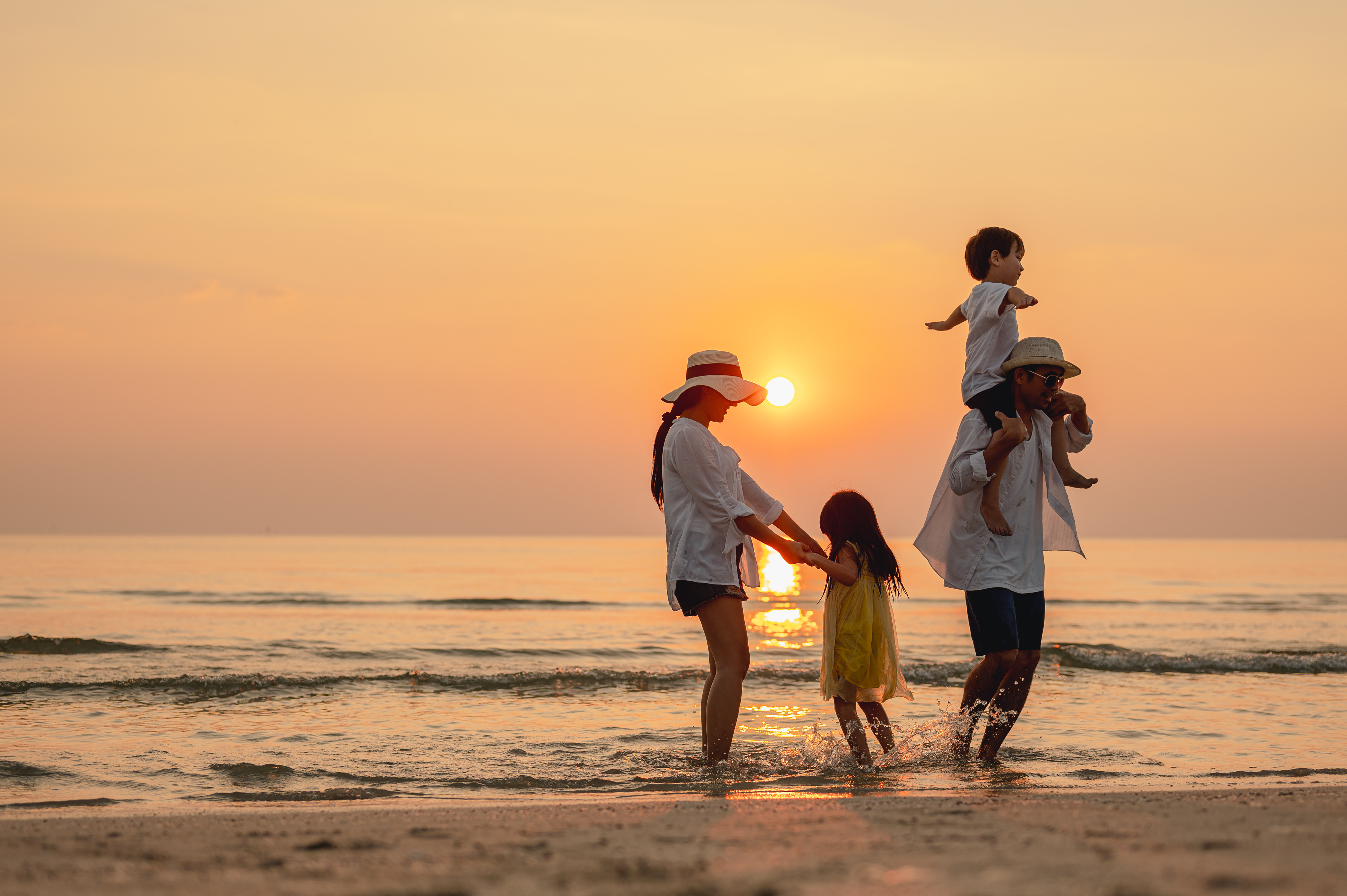 Family on the beach at sunset